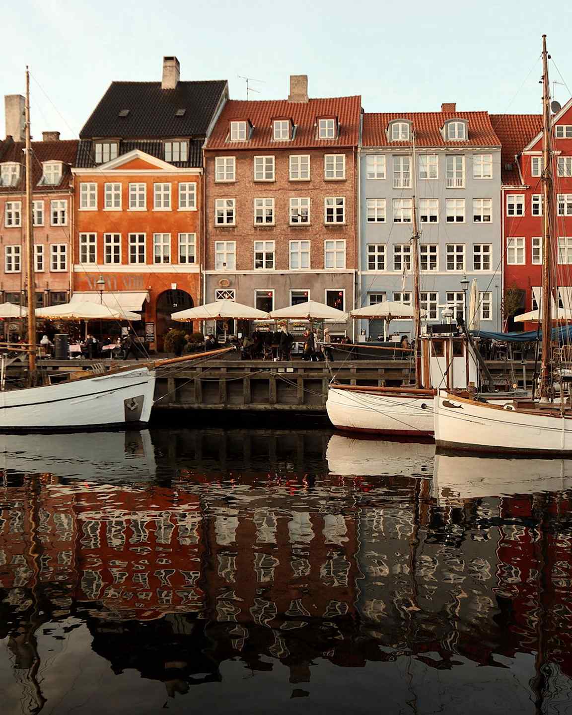 Färgglada byggnader vid en kaj med båtar i vattnet. (AI-genererad text)