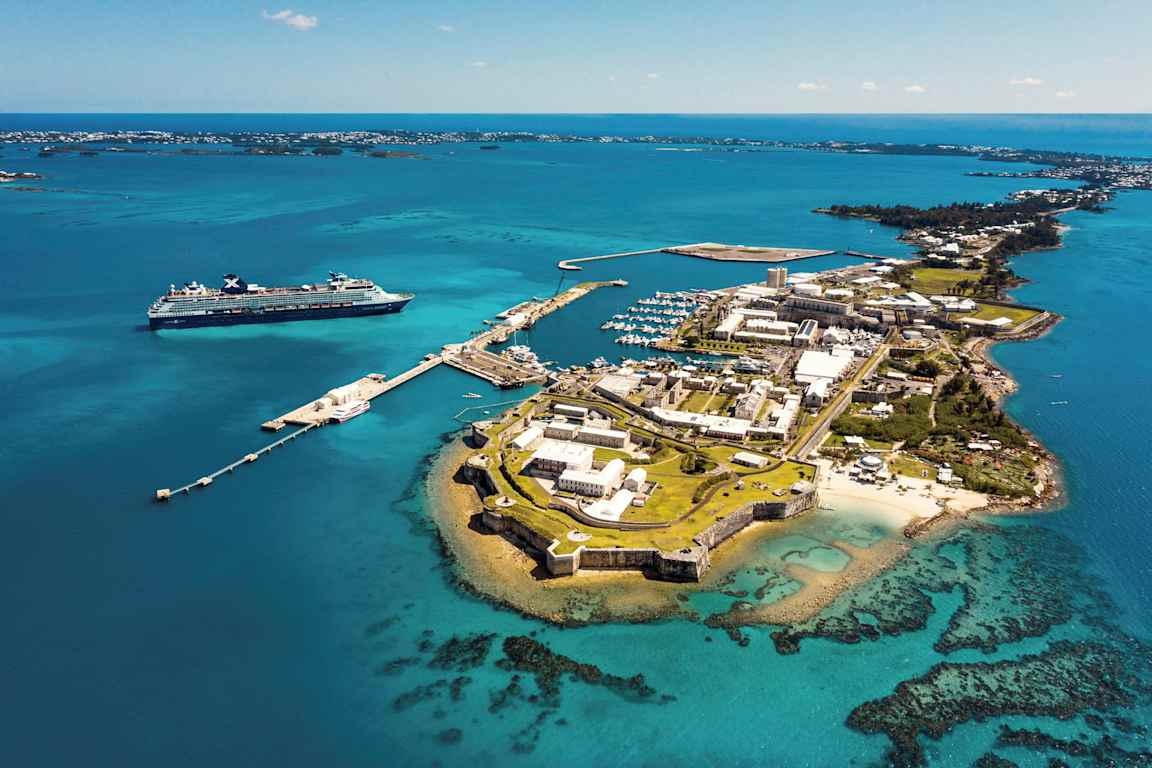 Flygfoto av en kuststad med hamn och kryssningsfartyg i närheten. (AI-genererad text)