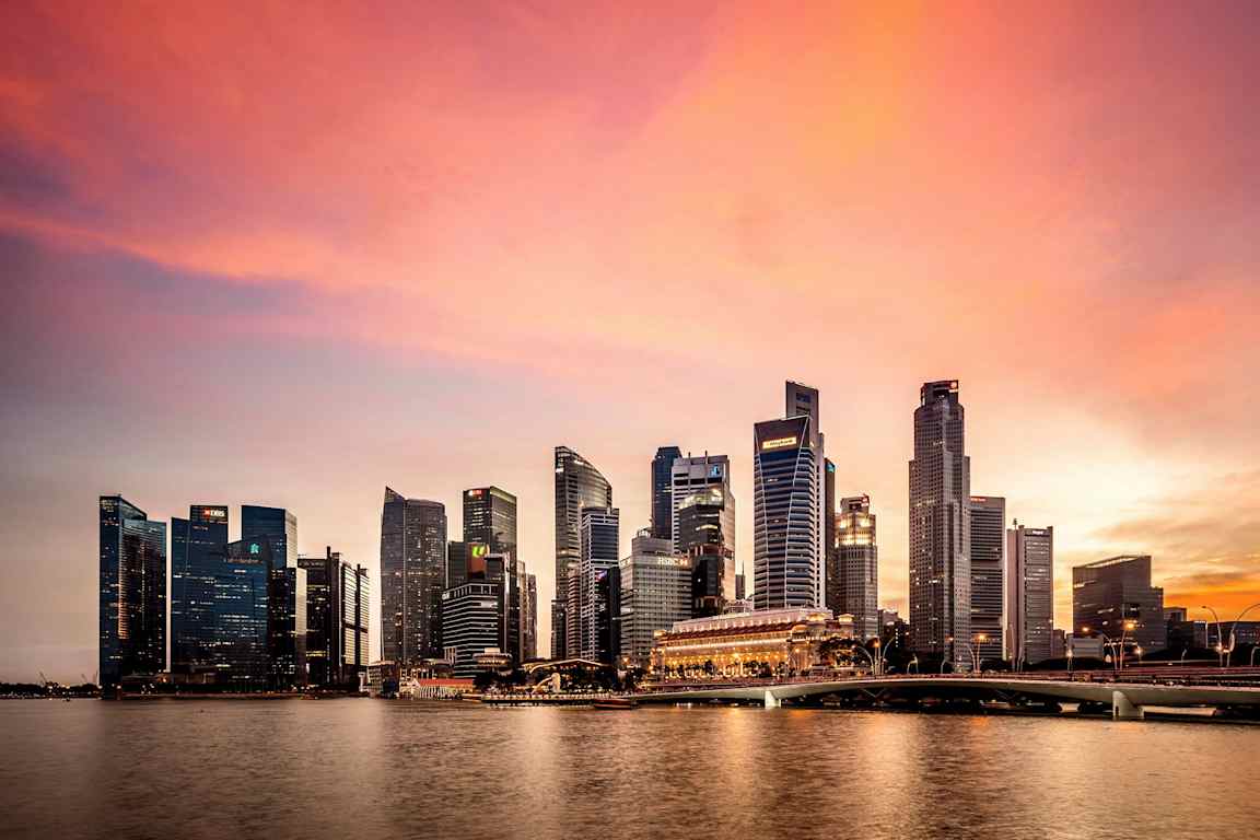 Skyskrapor vid en flod i solnedgång. (AI-genererad text)