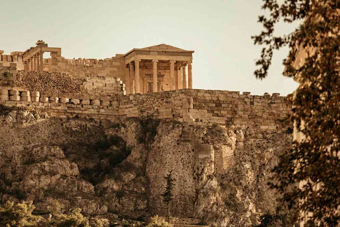 Ett antikt tempel på Akropolis med stengärde och klippor. (AI-genererad text)