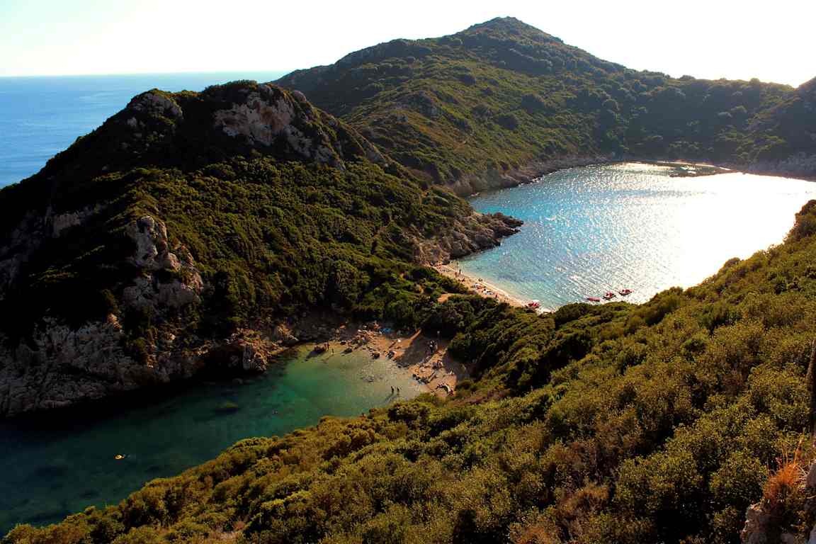 En liten vik med klart blått vatten omgivet av gröna berg. (AI-genererad text)