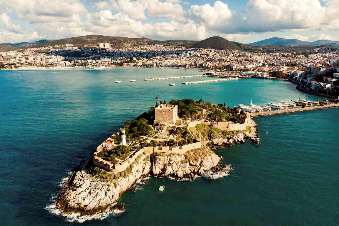 En fästning på en liten ö framför en kuststad. (AI-genererad text)