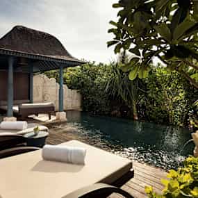 Utomhusområde med solstolar, pool och grönska. (AI-genererad text)