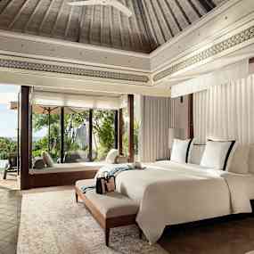 Lyxigt hotellrum med stor säng, fönster mot terrass och utomhuspool. (AI-genererad text)