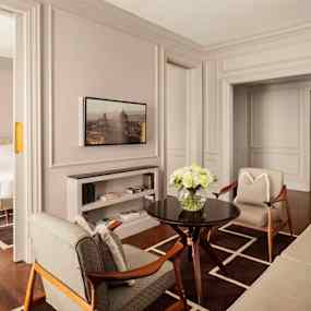 Ett elegant rum med sittgrupp och ett sovrum intill. (AI-genererad text)