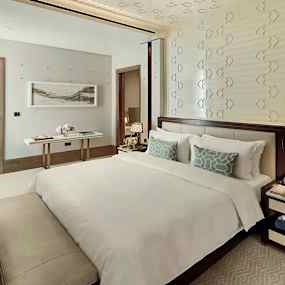 Ett elegant sovrum med en stor säng och smakfull inredning. (AI-genererad text)