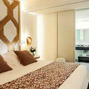 Modern hotellrum med dubbelsäng och utsikt mot badrum. (AI-genererad text)