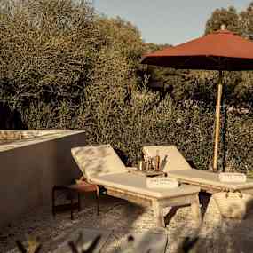 Solstolar och solparasoll vid en mindre pool. (AI-genererad text)