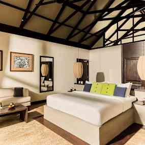 Dubbelrum med dubbelsäng och inredning i ljusa färgtoner. (AI-genererad text)