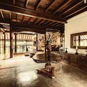 Interiör av ett rum med trädetaljer och ett runt bord. (AI-genererad text)