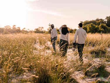 Guide visar två personer naturen på Wilderness Vumbura Plains