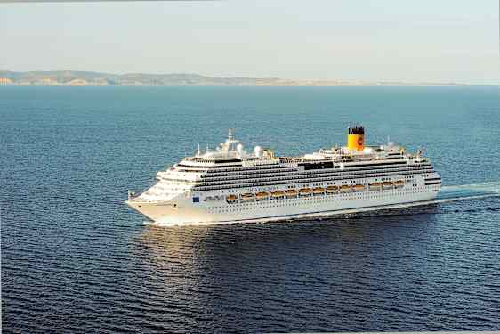 Ett stort kryssningsfartyg på havet, med land i bakgrunden. (AI-genererad text)