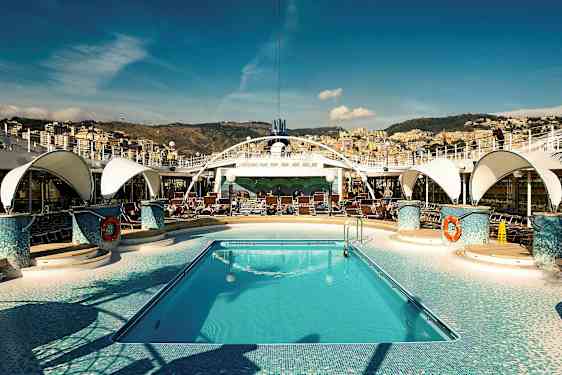 En pool på ett kryssningsfartyg med solstolar runt omkring och en stad i bakgrunden. (AI-genererad text)