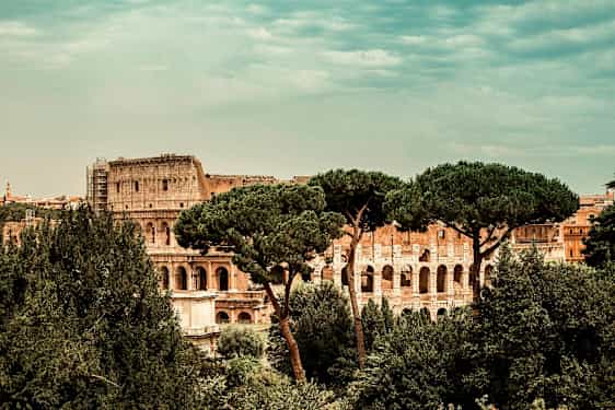 Vy över Colosseum i Rom, omgiven av träd. (AI-genererad text)