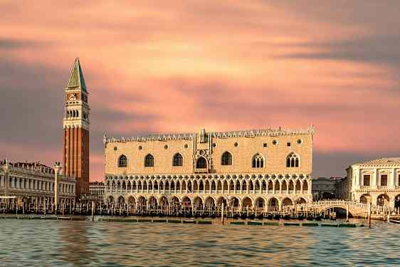 Bild av Dogepalatset och Kampanilen i Venedig med rosa kvällshimmel. (AI-genererad text)