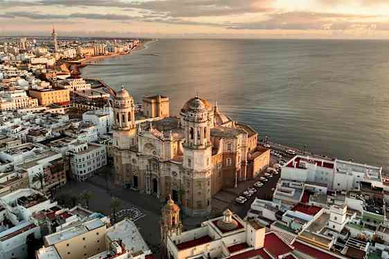 Flygfoto av Cadiz, med katedralen och havet i solnedgången. (AI-genererad text)