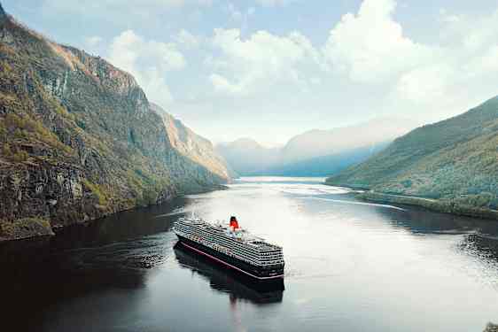 Ett kryssningsfartyg färdas genom en fjord omgiven av höga berg. (AI-genererad text)