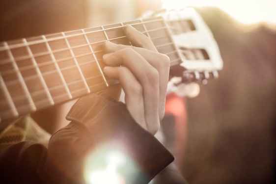 Gitarr och hand som tar accord