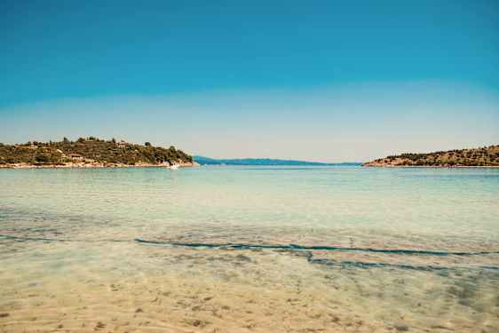 Klarblått vatten vid en strand