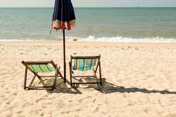 Strand med parasoll och solstolar