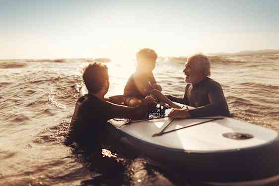 Familj på surfbräda i vatten