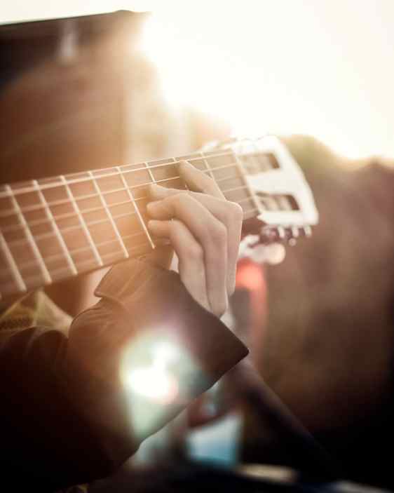 Närbild på gitarrhals och hand som tar accord