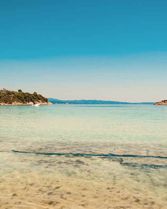 Klarblått vatten vid en strand