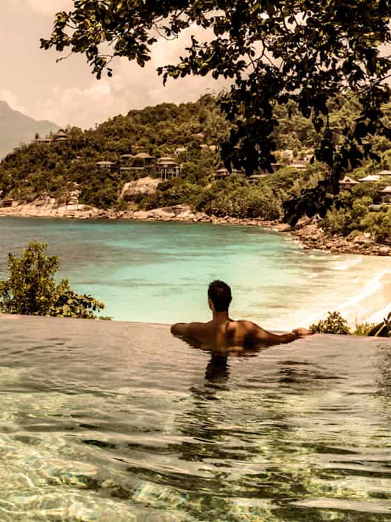 Man badar i infinitypool på Seychellerna