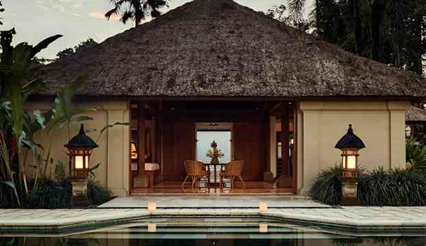 Strandvilla med halmtak och poolutsikt. (AI-genererad text)