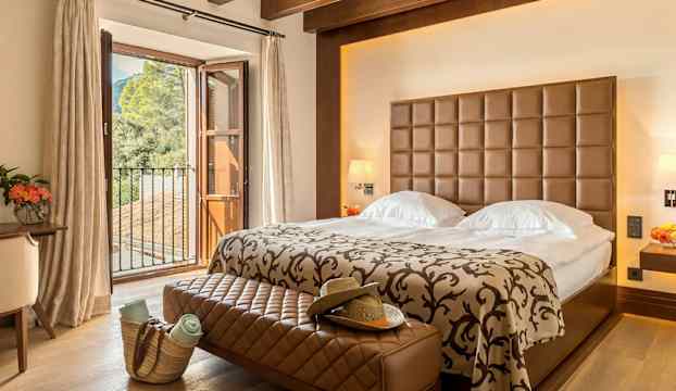 Ett sovrum med en dubbelsäng och ett stort fönster med utsikt mot naturen. (AI-genererad text)