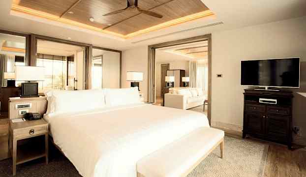 Hotellrum med en stor säng, sittgrupp och modern inredning. (AI-genererad text)