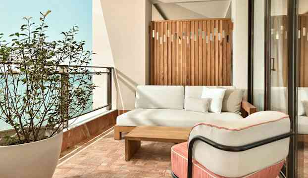 En terrass med soffa, fåtölj, bord och växt. (AI-genererad text)