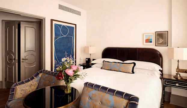 Ett elegant hotellrum med dubbelsäng och stilfull inredning. (AI-genererad text)