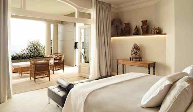 Ett elegant sovrum med havsutsikt och en möblerad terrass. (AI-genererad text)