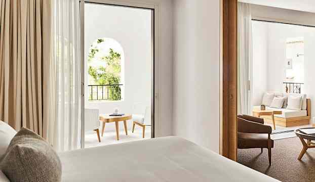 Ett hotellrum med utsikt mot en möblerad balkong. (AI-genererad text)