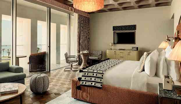 Ett välutrustat hotellrum med en dubbelsäng, sittgrupp och TV. (AI-genererad text)