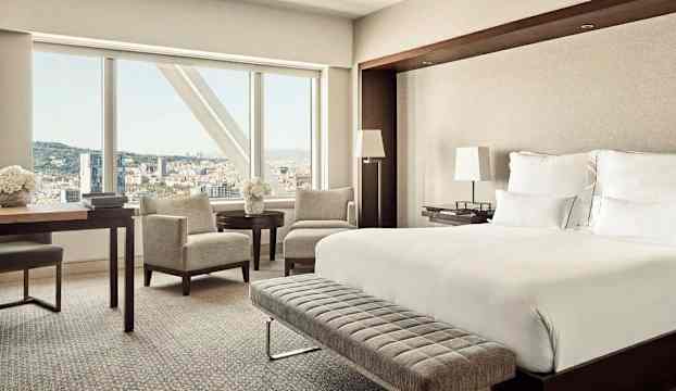 Modernt hotellrum med stora fönster och utsikt över staden. (AI-genererad text)