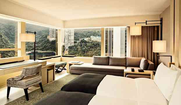 Hotellrum med modern inredning, stora fönster och utsikt över staden. (AI-genererad text)