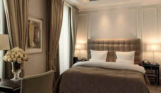 Ett elegant inrett hotellrum med en stor säng och inbjudande belysning. (AI-genererad text)