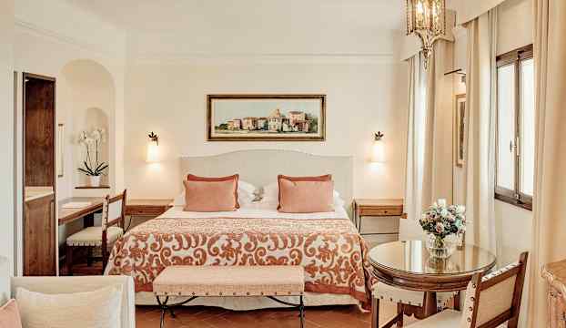 Elegant hotellrum med dubbelsäng, sittgrupp och stilrena detaljer. (AI-genererad text)