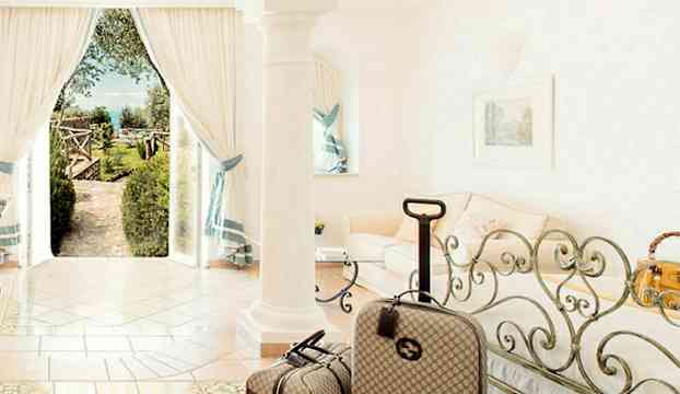 Ett ljust rum med resväskor och en utomhusvy genom ett öppet fönster. (AI-genererad text)