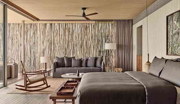 Modernt inrett sovrum med stora fönster och naturliga detaljer. (AI-genererad text)