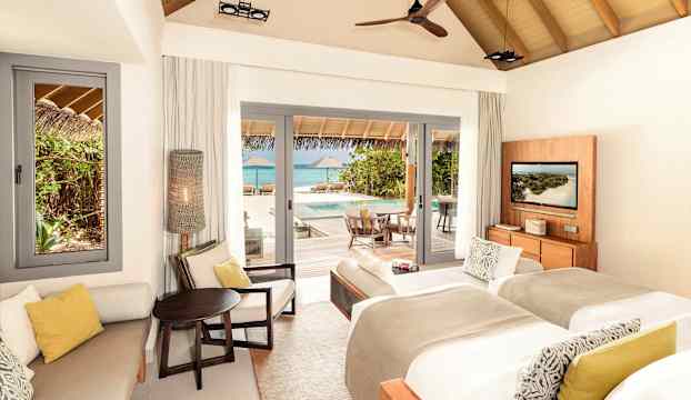 Ett strandnära hotellrum med utsikt över en pool och havet. (AI-genererad text)