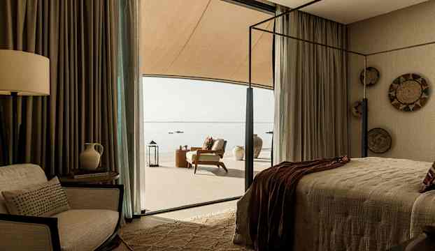 Sovrum med modern inredning och en terrass som vetter mot havet. (AI-genererad text)