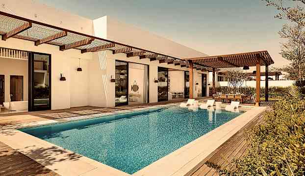 Utomhusområde med en swimmingpool, träaltan och delvis skuggade sittplatser. (AI-genererad text)