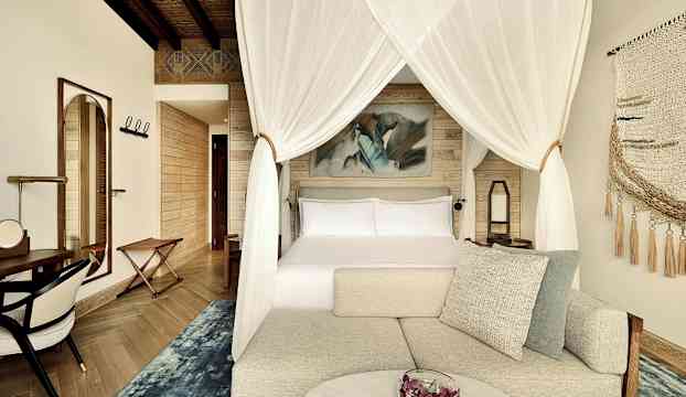 Lyxigt hotellrum med himmelssäng, modern inredning och bekväma möbler. (AI-genererad text)