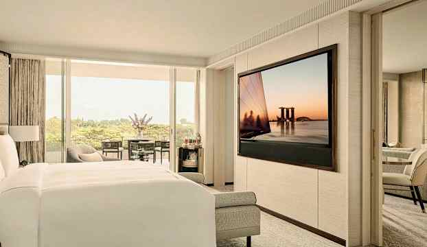 Ett modernt hotellrum med en säng, en stor TV och en balkong med utsikt. (AI-genererad text)