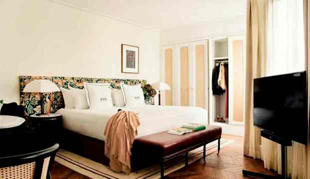 Ett hotellrum med en säng, TV, sittplats och garderober. (AI-genererad text)