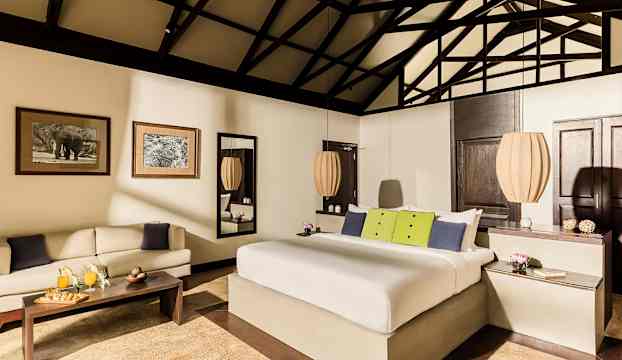 Dubbelrum med dubbelsäng och inredning i ljusa färgtoner. (AI-genererad text)