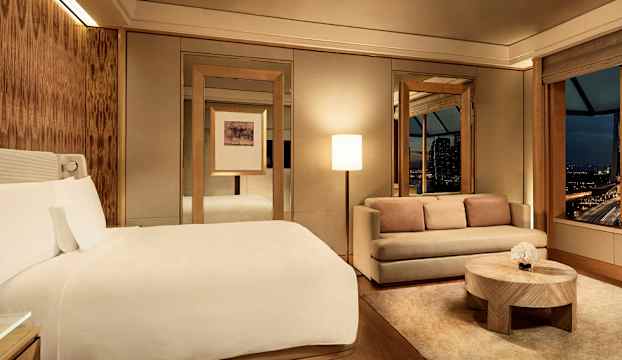 Hotellrum med dubbelsäng, soffa och bord. (AI-genererad text)